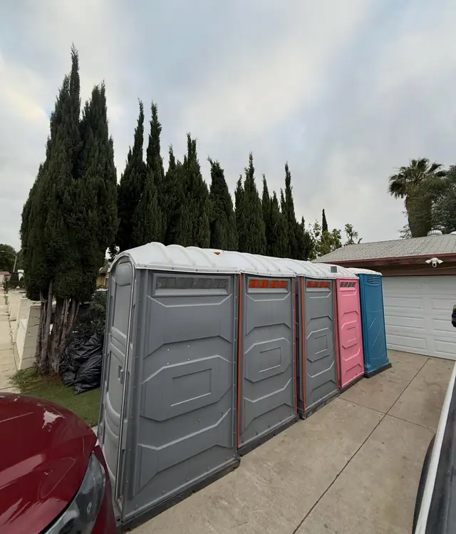 Porta potties lined up along a driveway with truck access