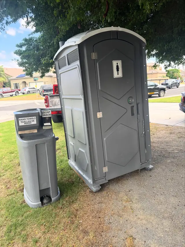 Two-sink handwashing station beside a porta potty