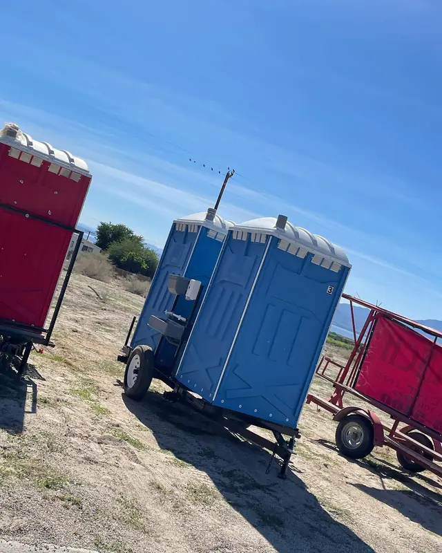 Porta potties on an open, windy lot